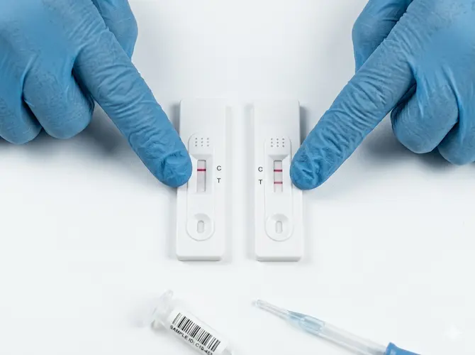 Tiras reactivas de diagnóstico rápido mostrando resultado positivo y negativo sobre superficie blanca de laboratorio clínico, ilustrando la interpretación de falsos positivos y falsos negativos