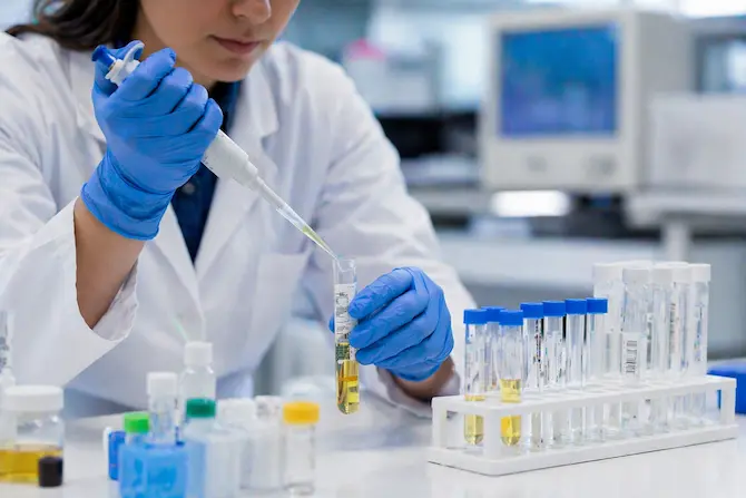 Laboratorista clínico procesando muestra de orina en tubo de ensayo para análisis toxicológico, con reactivos certificados COFEPRIS sobre superficie de laboratorio