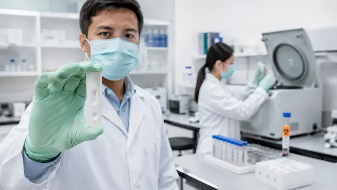 Técnico de laboratorio clínico sosteniendo prueba rápida de antígenos para SARS-CoV-2 en entorno de laboratorio profesional